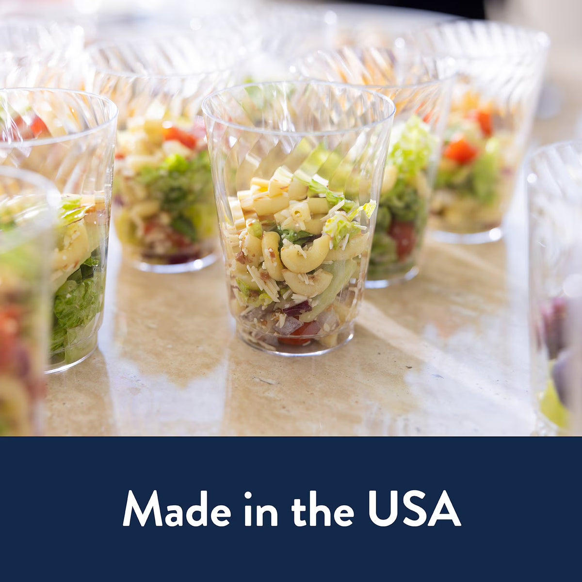 Chinet Crystal Plastic Cups 14 oz 60 Pack Clear Disposable Cups with salad on a table with 'Made in the USA' text at the bottom.